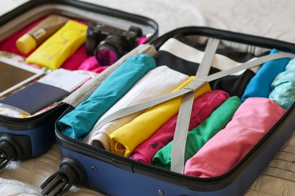 An open suitcase packed with colourful clothes